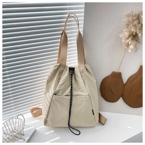 Detail of beige nylon drawstring backpack showing the woven cord and durable fabric texture
