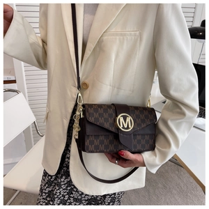 Gros plan du sac à main marron avec motif M et boucle en métal doré avec logo