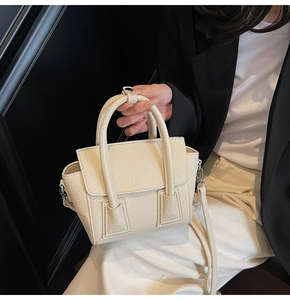 Close-up of cream white pebble grain leather handbag with elegant dual top handles