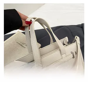 Detail showing cream leather texture and comfortable top handle with silver hardware