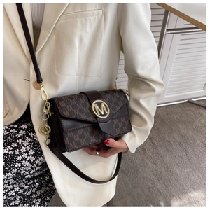 Détail du sac bandoulière marron avec motif M et grande boucle en métal doré