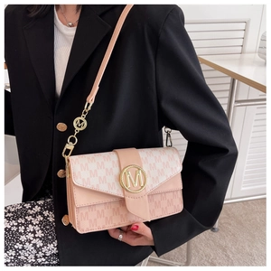 Détail du sac bandoulière rose clair avec motif jacquard M et boucle en métal doré