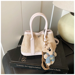 Detailed texture of straw woven bag with pink leather trim and cute bear charm