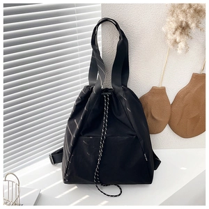Close-up of black drawstring backpack with silver curved stripes and durable nylon texture