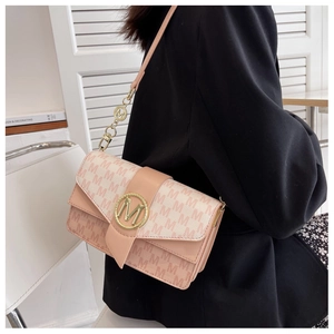 Détail du sac à main rose avec monogramme M, boucle dorée et bandoulière à chaîne en métal