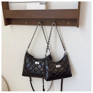 Détail de deux sacs matelassés noirs avec fermoir rotatif argenté et lanières