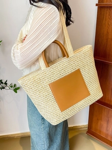 Minimalist cream woven straw tote bag with brown leather handles for summer daily commute