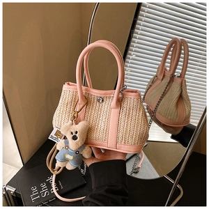 Macro shot of pink leather trim on woven straw bag with a cute plush bear charm