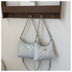 Détail du sac matelassé en cuir verni gris clair avec chaîne argentée et fermoir pivotant