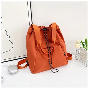 Detail of orange drawstring backpack with durable nylon fabric and adjustable black cord
