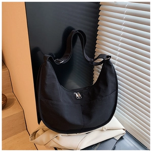 Detail view of black nylon crescent bag with double zippers and adjustable wide strap