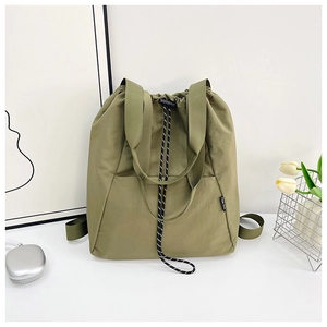 Detail view of military green nylon drawstring tote bag with black and white woven cord