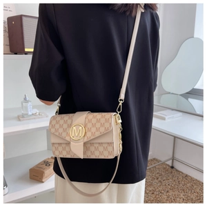Détail du sac bandoulière jacquard beige avec boucle logo M dorée et sangle réglable
