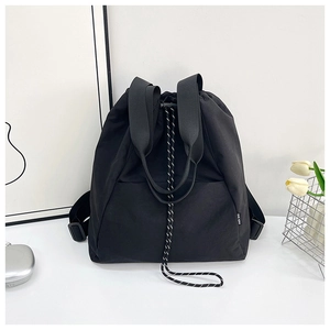 Detail of multi-functional black drawstring backpack with durable fabric and side label