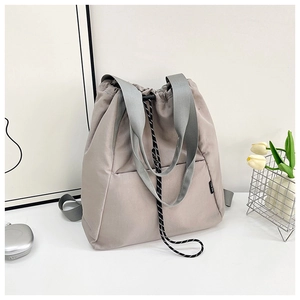 Detail of light grey multi-functional nylon drawstring backpack with brand label