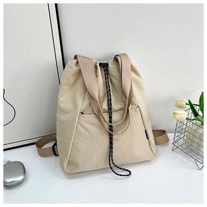 Detail of minimalist beige nylon drawstring bucket bag with brown wide shoulder straps