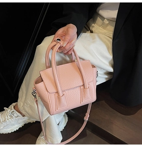 Macro view of pink lychee textured leather handbag showing premium stitching and magnetic closure