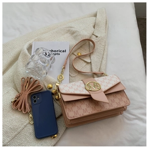 Détail du sac bandoulière rose et blanc avec motifs de lettres M et boucle dorée