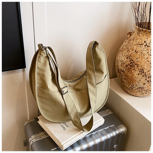 Detail of minimalist nylon crescent bag with adjustable strap on luggage