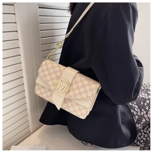 Détail du sac bandoulière avec motif monogramme M et boucle ronde en métal doré