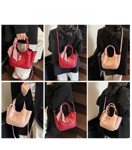 Detail view of crocodile-patterned bucket bags with silk scarves and metal locks