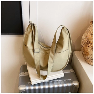 Detail of the adjustable shoulder strap and silver buckle on a canvas dumpling bag