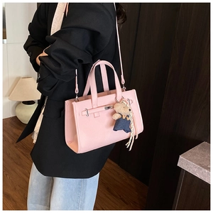 Pink lychee grain leather handbag with silver clasp detail and cute teddy bear charm