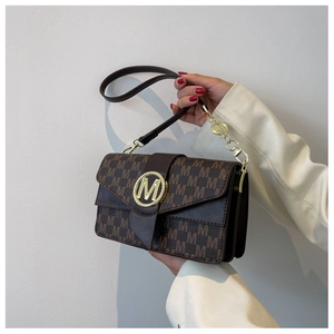 Détails d'un sac à main monogramme vintage avec boucle logo M dorée et plis accordéon