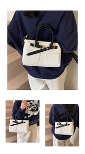 Detail of contrast color bucket bag with lychee texture and gold buckle accents