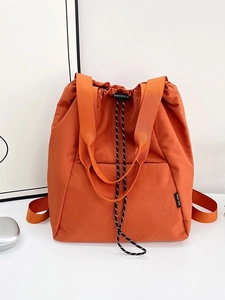 Orange nylon drawstring backpack with top handles and water-resistant fabric design