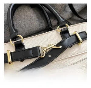 Close-up of golden metal hardware and beige lychee texture leather on bucket bag