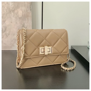 Détails du sac à bandoulière matelassé beige avec chaîne dorée et fermoir rotatif en métal