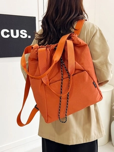 Versatile orange drawstring backpack with wide shoulder straps in a minimalist casual style