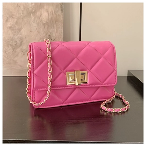 Détail du sac matelassé rouge rose avec fermoir doré et bandoulière en chaîne élégante