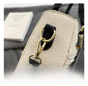 Macro shot of high-quality gold metal hooks and textured leather stitching details