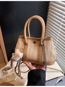 Woven straw beach bag with leather handles and a cute bear charm for summer