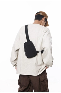 Detaillierte Rückansicht einer schwarzen minimalistischen Umhängetasche an einem Model