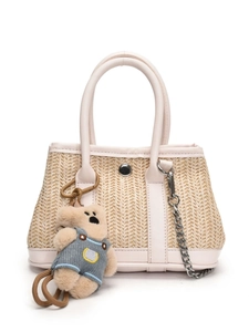 Beige woven straw beach bag with light pink leather trim and a cute teddy bear charm