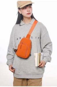 Detail einer orangefarbenen, wasserdichten Nylon-Umhängetasche mit verstellbarem Riemen