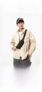 Detailed view of black nylon crossbody bag on model wearing a beige shirt