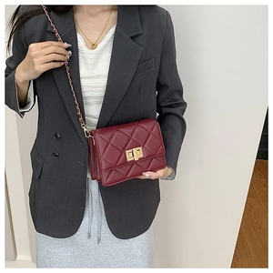 Détail du sac bandoulière en cuir matelassé bordeaux avec fermoir doré et chaîne
