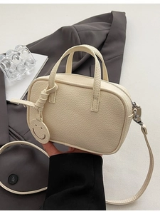 Chic beige lychee grain leather crossbody bag with iconic smiley face charm and top handle
