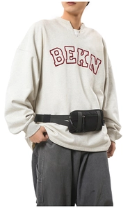 Detail of black nylon sports waist bag with dual zippers worn on a model's waist
