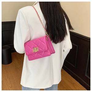 Détail d'un sac bandoulière rose matelassé avec fermoir doré et bandoulière en chaîne