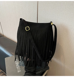 Detailaufnahme der schwarzen Fransen-Beuteltasche aus Wildleder mit goldener Metallschnalle