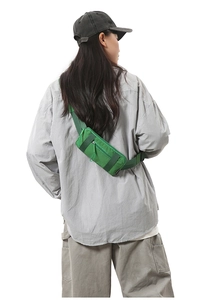 Rear view of a green nylon sports waist bag with adjustable strap and multiple pockets