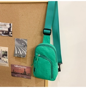 Nahaufnahme der leuchtend grünen Nylon-Halbmondtasche mit robustem Reißverschluss und Gurt
