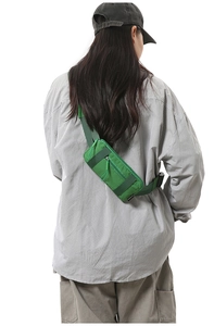 Detail of green nylon crossbody bag with adjustable strap and durable outdoor hardware