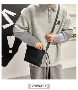 Close-up of lightweight black nylon envelope crossbody bag with adjustable shoulder strap