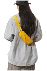 Close-up of bright yellow nylon sports waist bag worn as a crossbody back pack